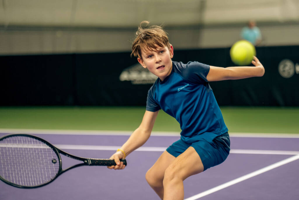 Ung Små Lirare-spelare slår en forehand